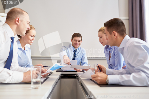 Image of group of smiling businesspeople meeting in office