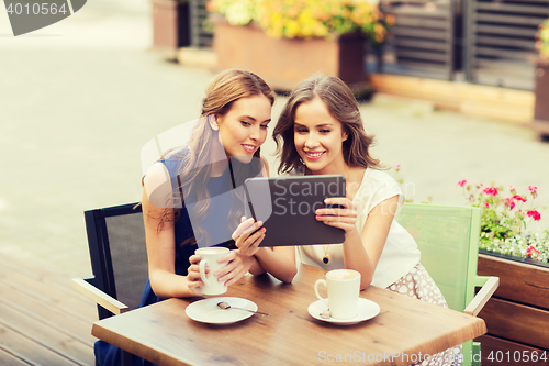 Image of young women with tablet pc and coffee at cafe