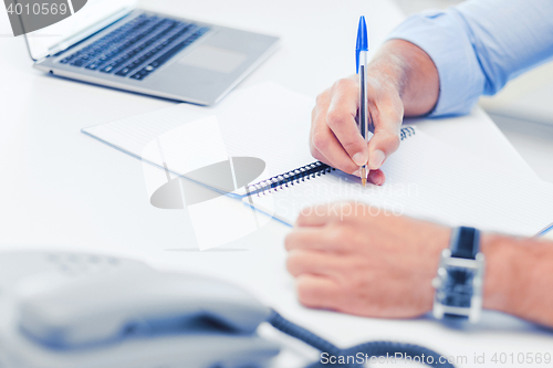 Image of businessman writing in notebook