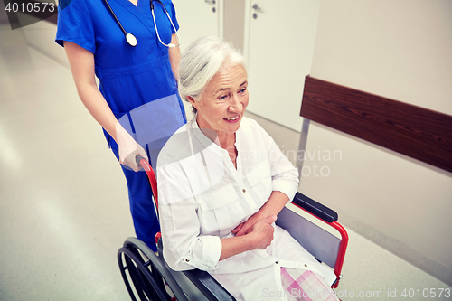 Image of nurse with senior woman in wheelchair at hospital