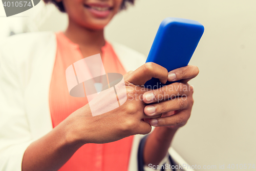 Image of close up of african woman with smartphone in city
