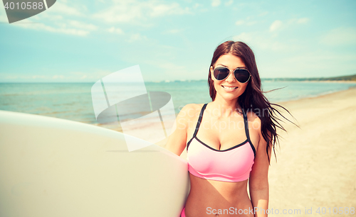 Image of smiling young woman with surfboard on beach