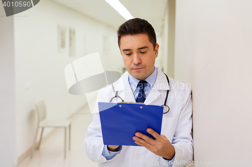 Image of doctor writing to clipboard at hospital