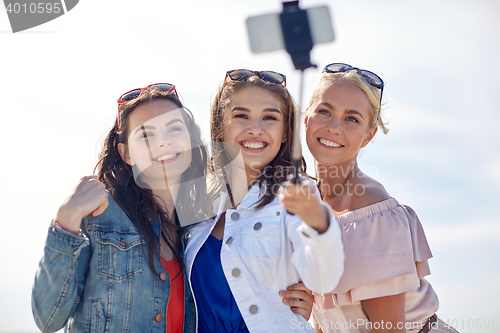 Image of group of smiling women taking selfie on beach