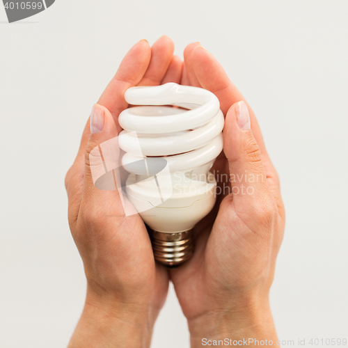 Image of close up of hands holding energy saving lightbulb