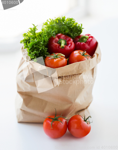 Image of close up of paper bag with vegetables and greens