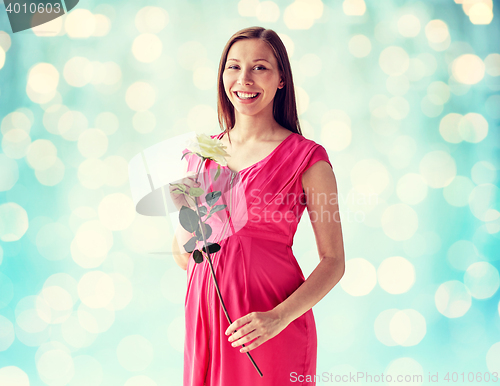 Image of happy pregnant woman with rose flower