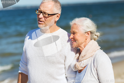 Image of happy senior couple hugging on summer beach