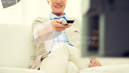 Image of close up of happy senior woman watching tv at home