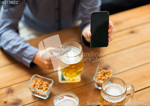 Image of close up of friends with smartphone and beer