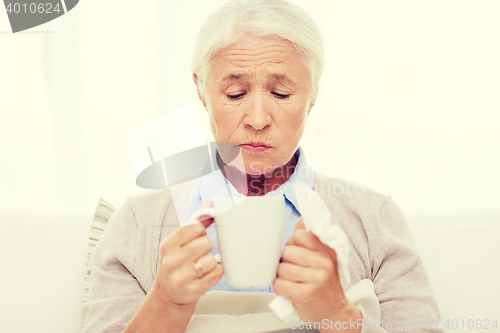 Image of sick senior woman drinking hot tea at home