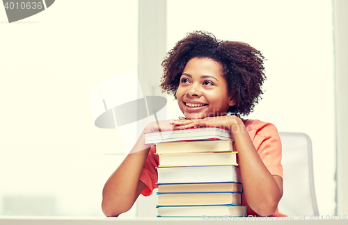 Image of happy african student girl with books at home