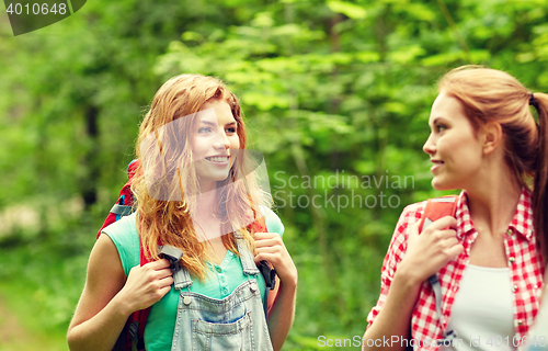 Image of group of smiling friends with backpacks hiking