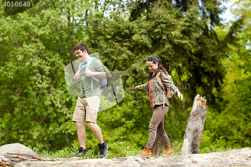 Image of happy couple with backpacks hiking outdoors