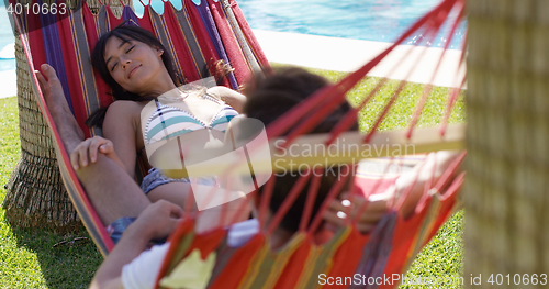 Image of Young holiday couple relaxing in a hammock