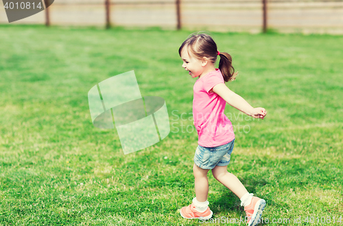 Image of happy little girl running on green summer field