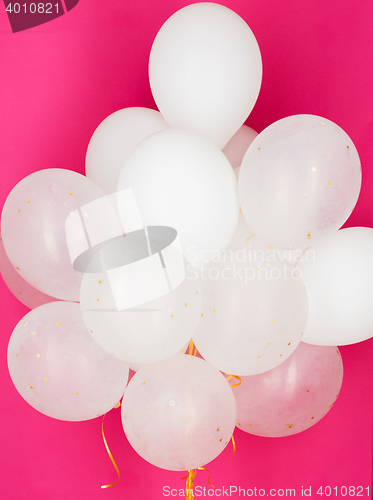 Image of close up of white helium balloons over pink