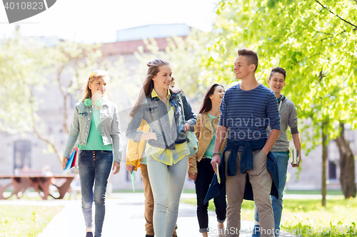 Image of group of happy teenage students walking outdoors