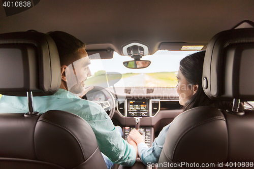 Image of happy man and woman driving in car