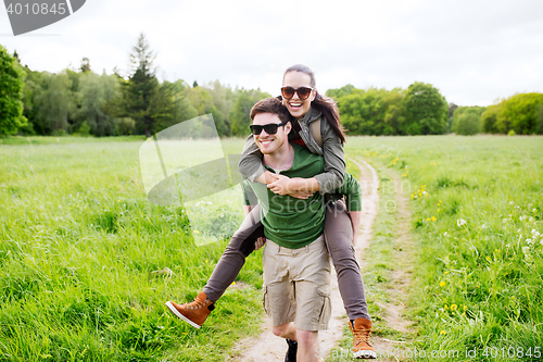 Image of happy couple with backpacks having fun outdoors