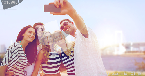 Image of happy friends taking selfie by smartphone in tokyo