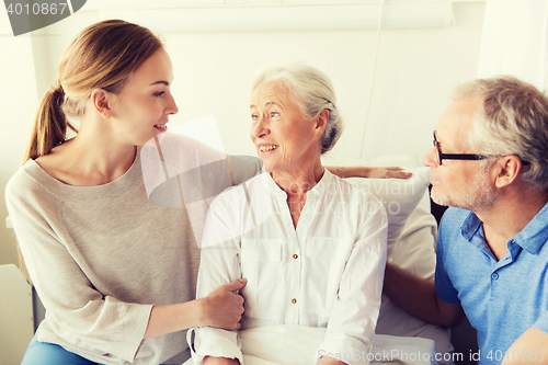 Image of happy family visiting senior woman at hospital