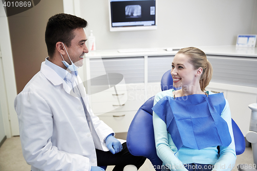 Image of happy male dentist with woman patient at clinic