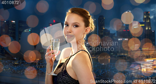 Image of young asian woman drinking champagne at party