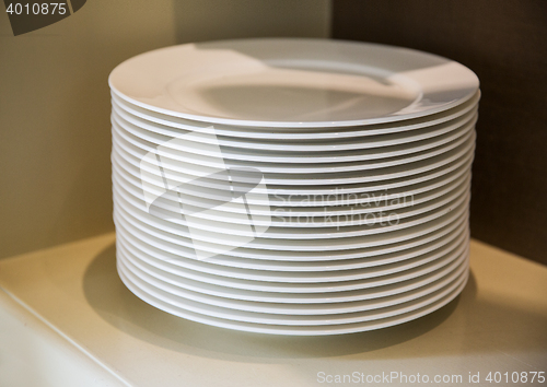 Image of close up of plates on cupboard shelf
