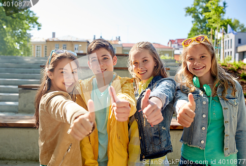 Image of happy students or friends showing thumbs up