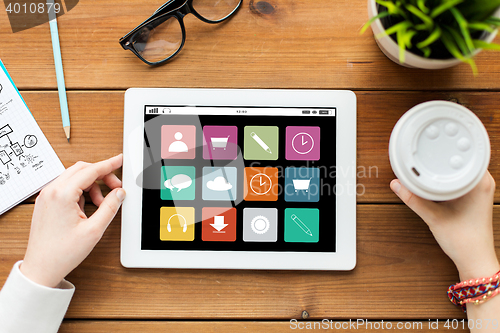 Image of close up of woman with tablet pc on wooden table