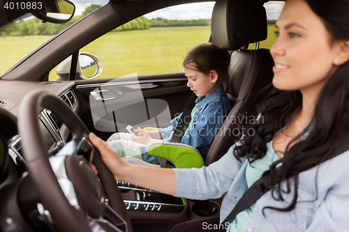 Image of happy woman with little child driving in car