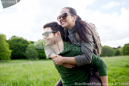 Image of happy couple with backpacks having fun outdoors