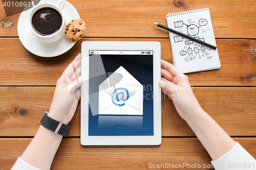 Image of close up of woman with tablet pc on wooden table