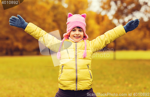 Image of happy little girl with raised hands outdoors