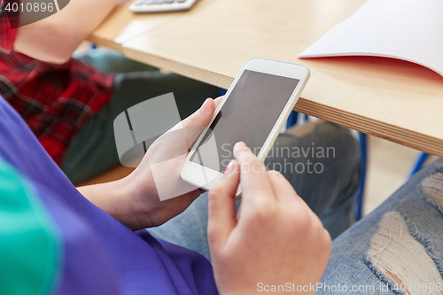 Image of student girl with smartphone texting at school