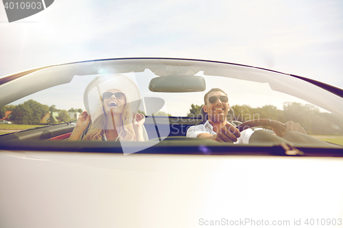 Image of happy man and woman driving in cabriolet car