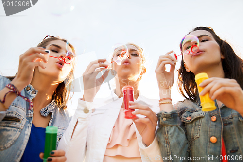 Image of young women or girls blowing bubbles outdoors