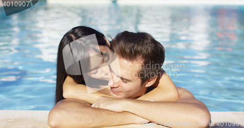 Image of Beautiful woman cuddles with her boyfriend in pool