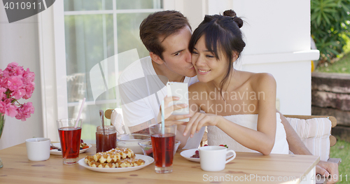 Image of Happy mixed race couple taking selfie