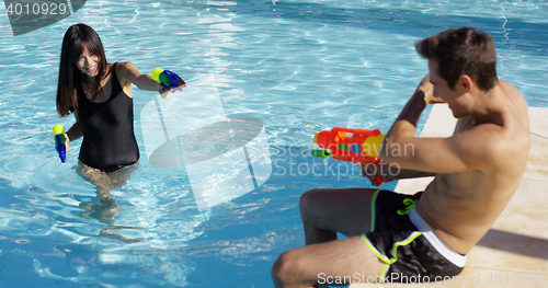 Image of Adults shooting shooting water guns at each other