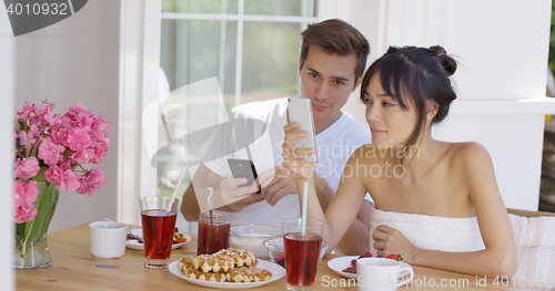 Image of Woman showing man something on her phone