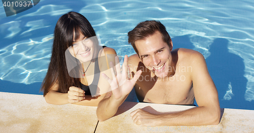 Image of Smiling couple standing in clear pool wave