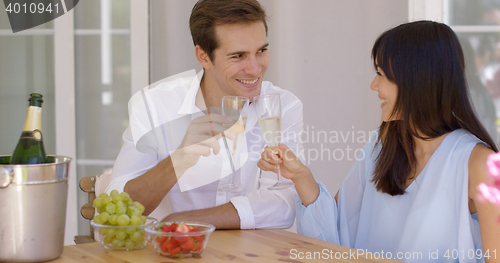 Image of Cheerful couple toasting champagne