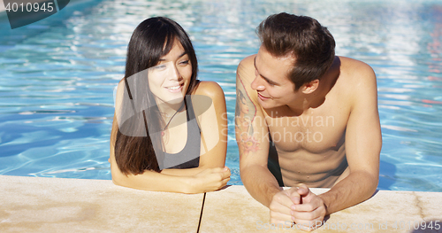 Image of Handsome brown haired couple in blue pool