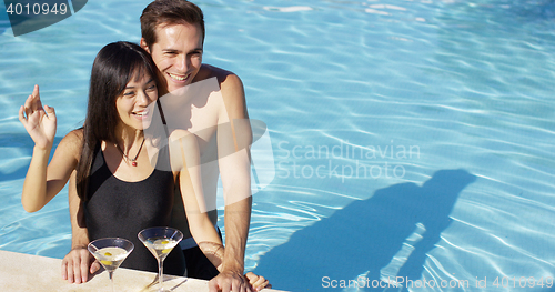 Image of Loving couple smooching at swimming pool