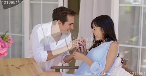 Image of Man proposing a marriage to woman with ring