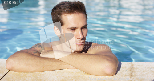 Image of Man stands alone in pool and smiles at camera