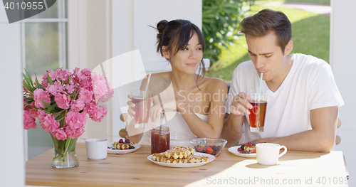 Image of Couple drinking iced tea at breakfast outside