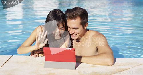 Image of Couple communicates with friends on digital device